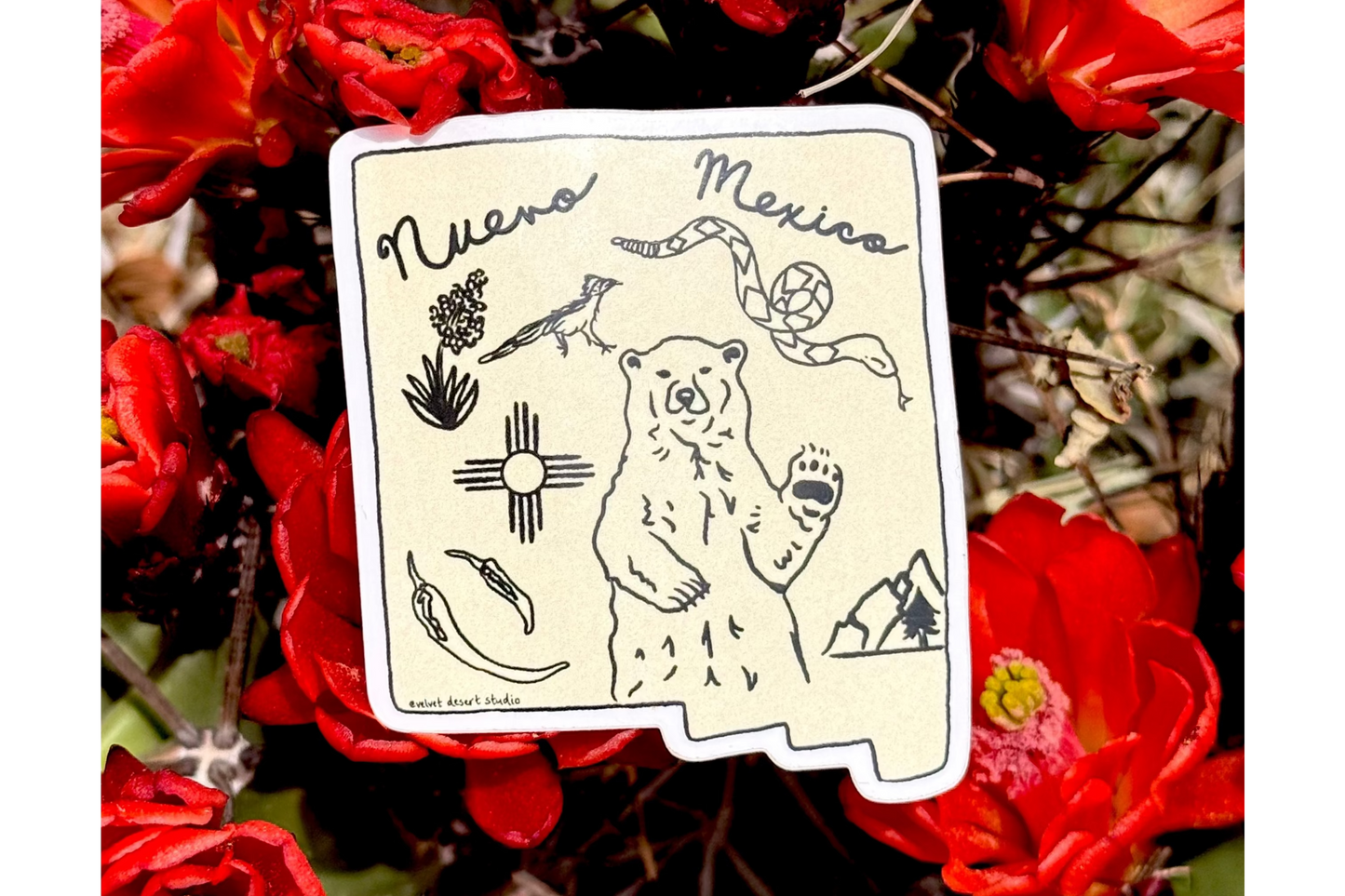 Red flowers with a New Mexico-themed sticker in the center
